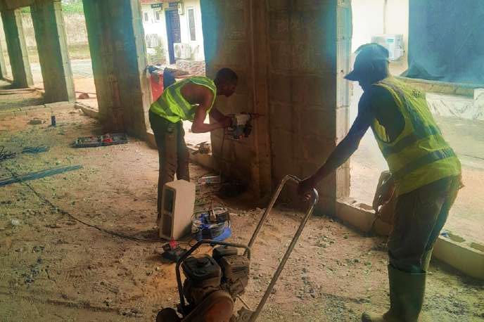 Plate compactor and rotary hammer in use on site