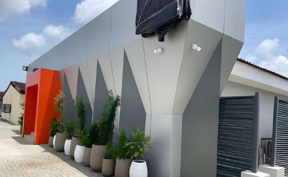 Geometric facade panels and planters beside the entrance — HFP Shopping Complex, Lagos